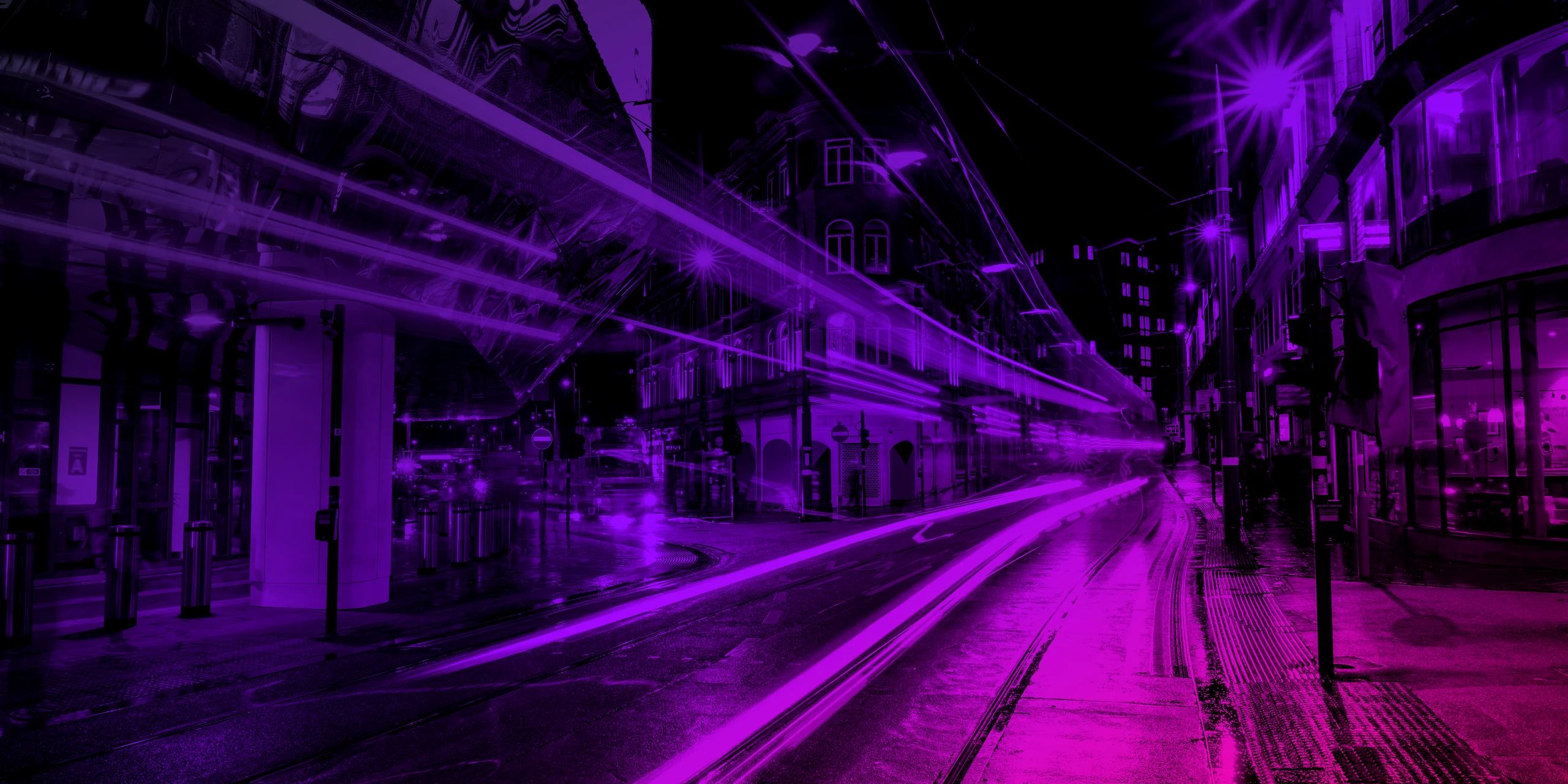 Light trails from a tram on a wet Birmingham street at night